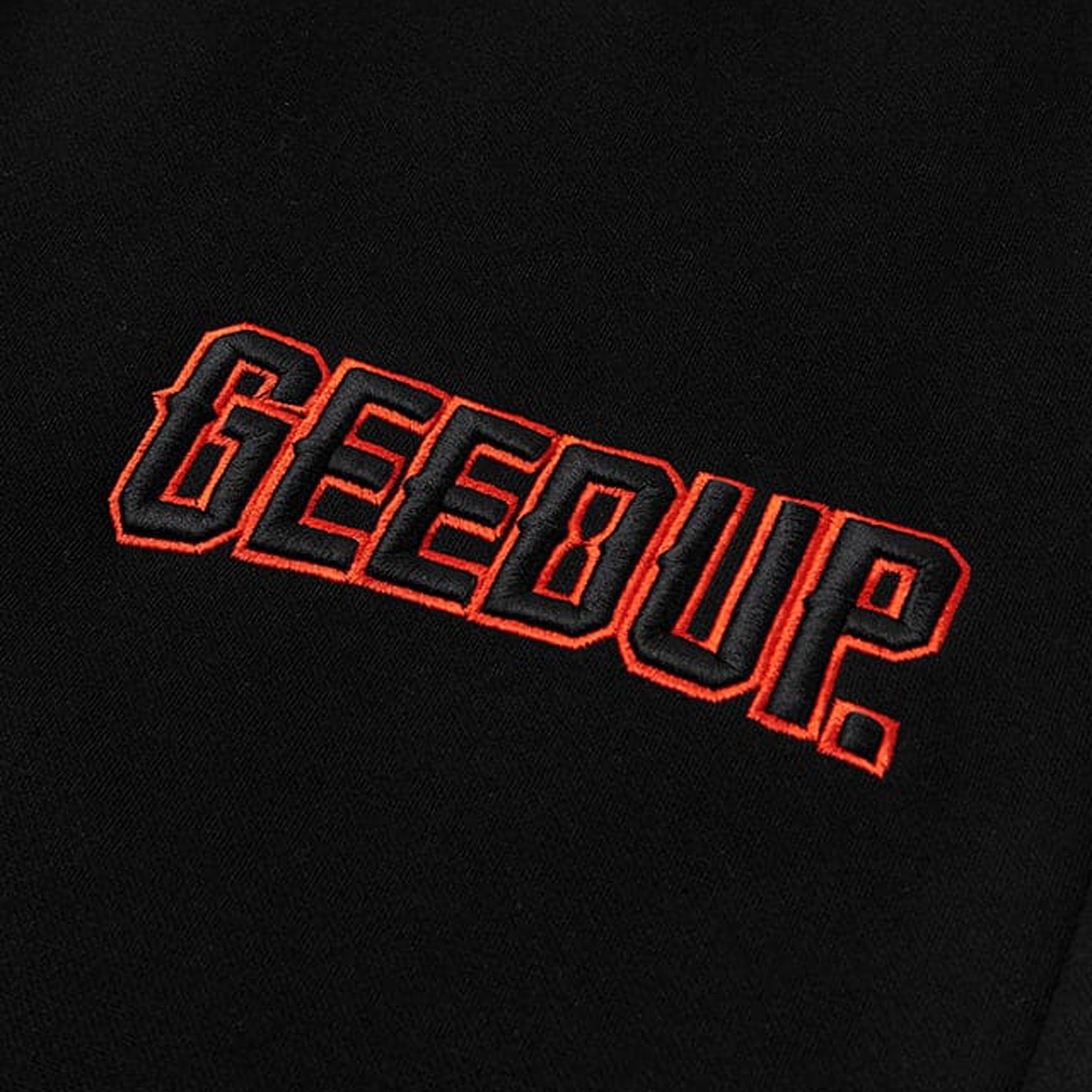 Geedup-Play-For-Keeps-EMB-Shorts-Black-Black-Orange-2024-logo-close-up